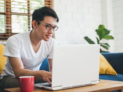 Young Asian man working with laptop at home